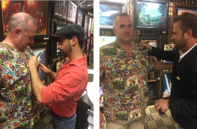 dentist modeling his new scrub sets and getting them signed by a cartoonist while he smiles