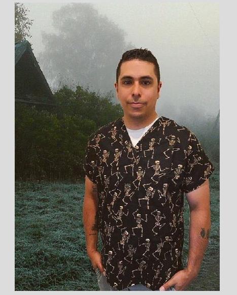 man standing outside wearing halloween scrub top with dancing skeletons