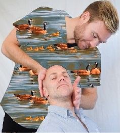 chiropractor working on man wearing print scrub top with ducks