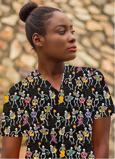 A woman wearing a halloween print scrub top with skulls skeletons
