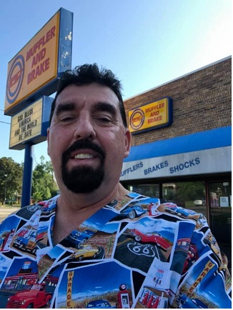man at auto shop wearing mens print scrub top